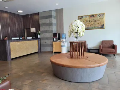 a lobby with a round table with flowers on it at Marsi Hotel @ Bangchak in Bangkok