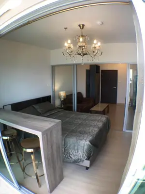 a bedroom with a large bed and a chandelier at Supalai Rama9 Monthly in Bangkok