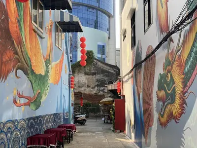 an alley with paintings on the side of a building at Taladnoi Paint House in Bangkok