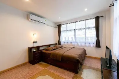 a bedroom with a bed and a large window at Taladnoi Paint House in Bangkok