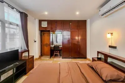 a bedroom with a bed and a large wooden door at Taladnoi Paint House in Bangkok
