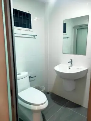 a white bathroom with a toilet and a sink at Bed By Boat @Nonthaburi Pier in Nonthaburi