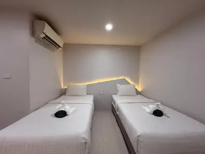 two beds in a small room with white sheets at Bed By Boat @Nonthaburi Pier in Nonthaburi