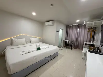 a hotel room with a large bed with two napkins on it at Bed By Boat @Nonthaburi Pier in Nonthaburi