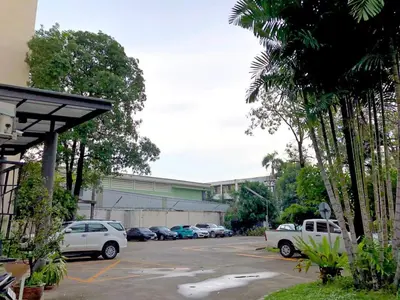 a parking lot with cars parked in front of a building at D-haus Ladprao Residence in Bangkok