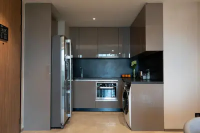 a kitchen with a refrigerator and a stove at Walton Suites Sukhumvit in Bangkok