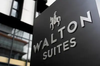 a sign in front of a building with the words walk to cure at Walton Suites Sukhumvit in Bangkok