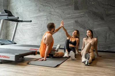 a man giving a high five to two women in a gym at Walton Suites Sukhumvit in Bangkok