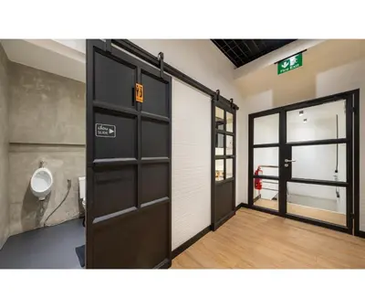 an open door in a bathroom with a urinal at Siam Subway Hostel and Café in Bangkok
