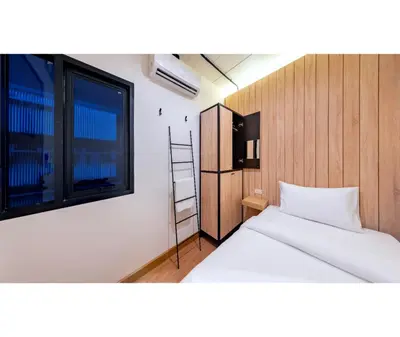 a small bedroom with a bed and a window at Siam Subway Hostel and Café in Bangkok