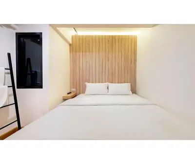 a bedroom with a white bed and a wooden wall at Siam Subway Hostel and Café in Bangkok