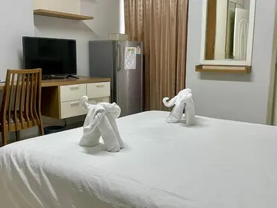 a bedroom with a bed with towel animals on it at ruamsab apartment1 in Bangkok