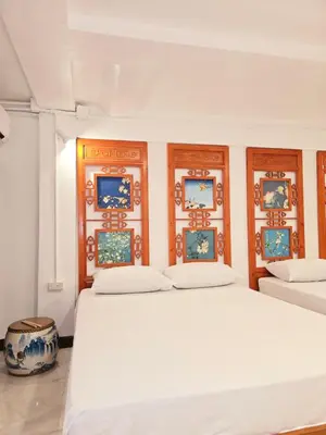 two beds in a room with paintings on the wall at Old Sрice 1 Sizzling Studio Queen Twin - No Stairs in Bangkok