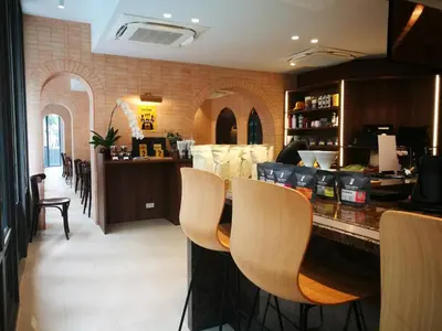 a bar in a restaurant with chairs and a counter at The Quarter Ploenchit by UHG in Bangkok