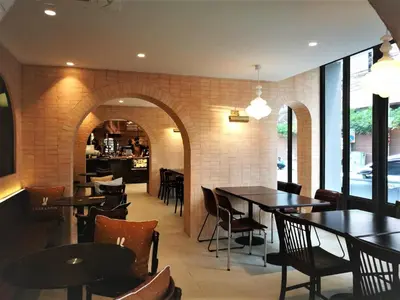 a restaurant with tables and chairs and a bar at The Quarter Ploenchit by UHG in Bangkok