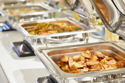 a row of trays of food on a counter at The Quarter Ploenchit by UHG in Bangkok
