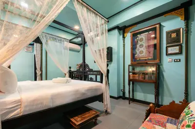 a bedroom with a bed with a canopy at DE Phanakron Boutique Hotel in Bangkok