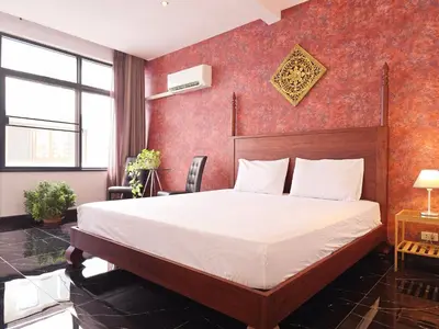a bedroom with a bed and a red wall at Old Sрice 5 Elegant Tranquility Your BKK Haven in Bangkok