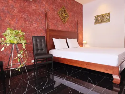a hotel room with a bed and a chair at Old Sрice 5 Elegant Tranquility Your BKK Haven in Bangkok