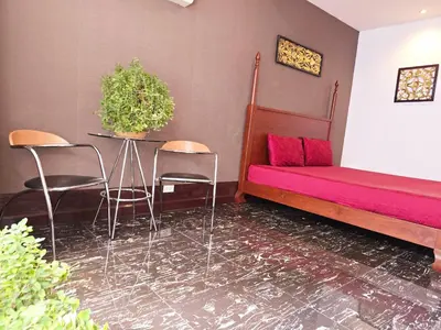 a room with a bed and chairs and a table at Old Sрice 3 Vintage Elegance in the Heart of BKK in Bangkok