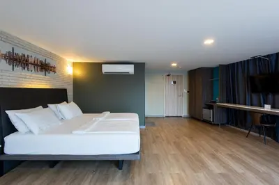 a bedroom with a large white bed and a television at BB Glass House บีบี กลาสเฮ้าส์ in Bangkok