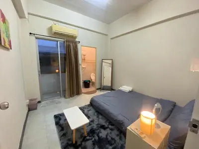 a bedroom with a bed and a table and a window at P29 in Bangkok