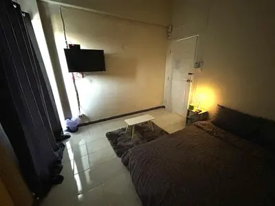 a bedroom with a bed and a table and a window at P29 in Bangkok