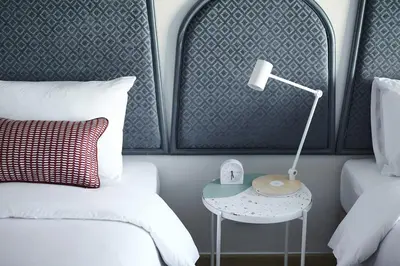 a bedroom with a bed and a table with a lamp at 56 Surawong Hotel Bangkok in Bangkok