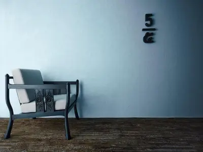 a chair sitting in front of a white wall at 56 Surawong Hotel Bangkok in Bangkok