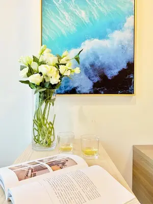 a table with a vase of flowers and a book at Chapter One Eco-Modern Suite (\u66fc\u8c37\u9ad8\u7aef\u9152\u5e97\u516c\u5bd3\uff09 in Bangkok