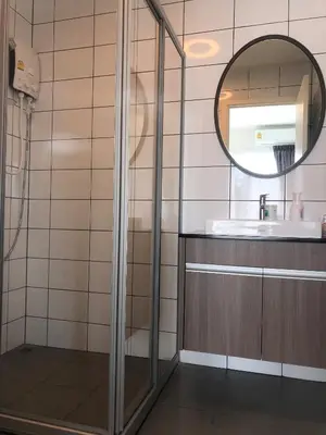 a bathroom with a shower and a mirror at Chapter One Eco-Modern Suite (\u66fc\u8c37\u9ad8\u7aef\u9152\u5e97\u516c\u5bd3\uff09 in Bangkok