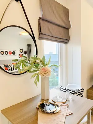 a dining room table with a vase of flowers on it at Chapter One Eco-Modern Suite (\u66fc\u8c37\u9ad8\u7aef\u9152\u5e97\u516c\u5bd3\uff09 in Bangkok