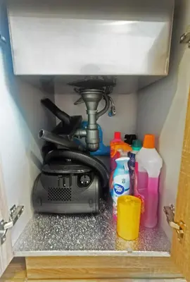 a kitchen under a sink with cleaningagents and bottles at Blossom Sathorn Hospitality \uff08\u66fc\u8c37\u9ad8\u7aef\u9152\u5e97\u516c\u5bd3\uff09 in Bangkok