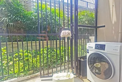 a washing machine sitting in front of a fence at Blossom Sathorn Hospitality \uff08\u66fc\u8c37\u9ad8\u7aef\u9152\u5e97\u516c\u5bd3\uff09 in Bangkok