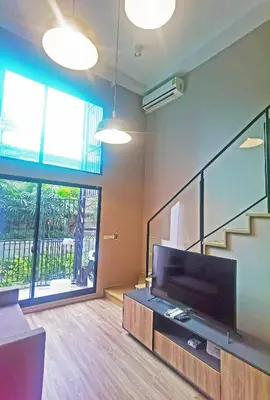 a living room with a large flat screen tv at Blossom Sathorn Hospitality \uff08\u66fc\u8c37\u9ad8\u7aef\u9152\u5e97\u516c\u5bd3\uff09 in Bangkok
