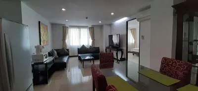 a living room with a couch and a tv at City Plaza Nana Hotel in Bangkok