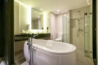a bathroom with a tub and a toilet and a sink at S Ratchada Leisure Hotel in Bangkok