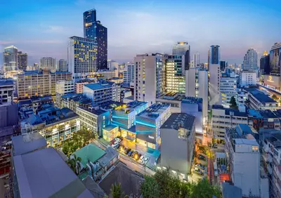 a city skyline at night with many tall buildings at The Quarter Silom by UHG in Bangkok