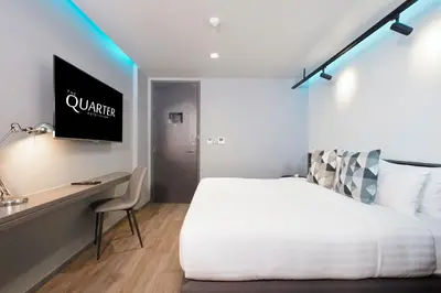 a bedroom with a bed and a desk with a television at The Quarter Silom by UHG in Bangkok