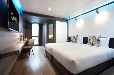 a hotel room with a large bed and a desk at The Quarter Silom by UHG in Bangkok