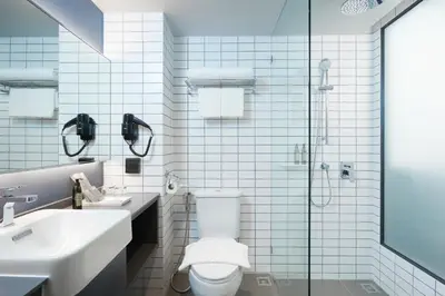 a bathroom with a toilet and a sink and a shower at The Quarter Silom by UHG in Bangkok