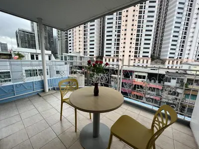 a room with a table and chairs and a balcony at V Check inn Sukhumvit 22 in Bangkok