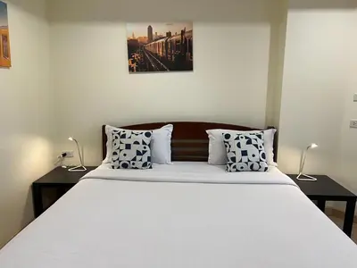 a bedroom with a large white bed with two tables at V Check inn Sukhumvit 22 in Bangkok