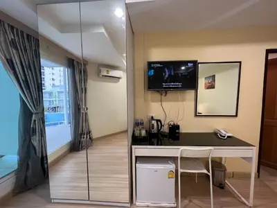 a room with a desk and a tv on the wall at V Check inn Sukhumvit 22 in Bangkok