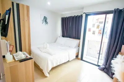 a small bedroom with a bed and a sliding glass door at ATC Residence in Bang Su
