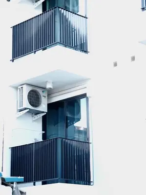 an apartment building with a balcony with a air conditioner at ATC Residence in Bang Su