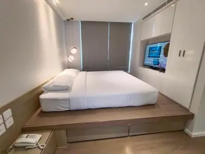 a bedroom with a large white bed and a phone at ashley hotel bkk in Bangkok