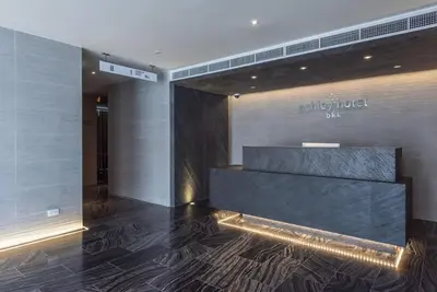 a lobby of a hotel with a sign on the wall at ashley hotel bkk in Bangkok