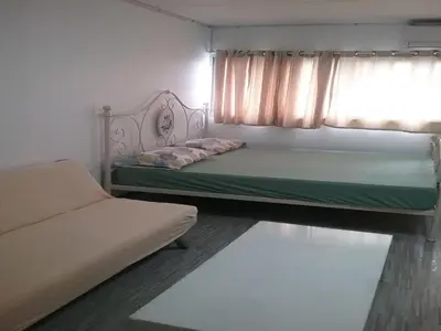 a bedroom with a bed and a couch and a window at Comfortable studio T8 Impact Bangkok Thailand in Nonthaburi