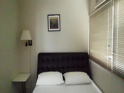 a bed with two pillows in a room with a window at Comfortable studio T8 Impact Bangkok Thailand in Nonthaburi